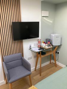 布莱顿霍夫Central ensuite guest unit with free on-street parking的客房设有书桌、椅子和电视。