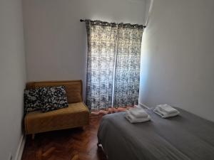 里斯本Alojamento Mercado Norte的客房设有床、椅子和窗户。