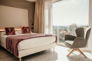 梅利德Hotel Lux Melide的卧室配有床、椅子和窗户。