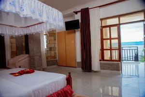 吉塞尼KIGUFI HILL, Agape Resort & Kivu Edge的一间卧室设有一张床和一个大窗户