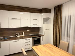Dubrave GornjeApartment Paradise Enver的厨房配有白色橱柜和木桌