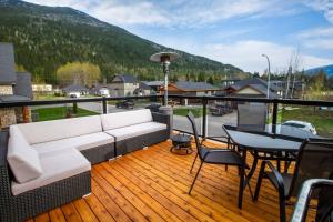 雷夫尔斯托克The best 2 bedrooms suite in Revelstoke!的甲板上配有一张沙发和一张桌子的门廊