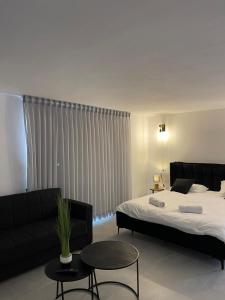 贝特谢安K.suites סוויטות בוטיק的一间卧室配有两张床、一张沙发和一张桌子