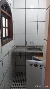 特林达德Pousada João e Maria的一间带水槽和冰箱的小厨房