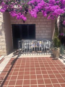 图彻皮Villa Bougenvilia Tomas的一群椅子坐在砖砌的庭院里,花朵紫色