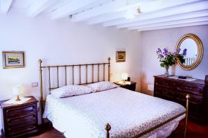 卡莱扎诺Bioagriturismo Podere Montisi的一间卧室配有床、两个梳妆台和镜子