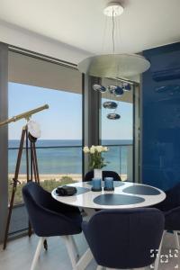 米兹多洛杰Wave Międzyzdroje - Luxury 2 Bedroom Suite with Salon and Kitchen的一间配备有桌椅的海景用餐室