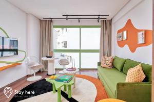 卡萨布兰卡Stayhere Casablanca - CIL - Vibrant Residence的客厅配有绿色沙发和桌子