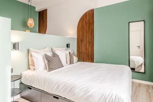 利沃诺Japandi, Appartamento Zona Porto Mediceo Livorno的卧室配有一张白色大床和镜子