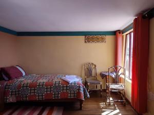 Comunidad YumaniHosteria LAS ISLAS的一间卧室配有一张床、两把椅子和一个窗户