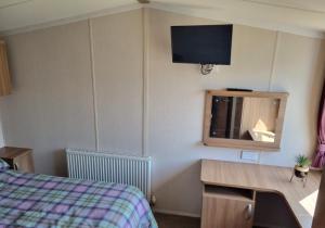 帕格汉姆Willow - Church Farm的一间卧室配有一张床、一张书桌和一台电视