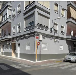 PaiportaApartamento tipo loft valencia的前面有一辆汽车停放的白色建筑