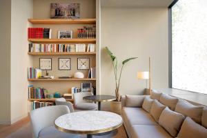 马德里艾塔纳万豪AC酒店的客厅配有沙发和桌子