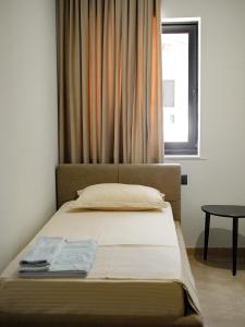 伏罗拉Rittson - Boutique Hotel的一张位于带窗户的房间的床