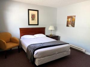 弗雷德里克顿纳斯瓦克堡垒汽车旅馆的配有一张床和一把椅子的酒店客房