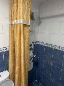 亚喀巴Al-Amer Chalets的浴室设有黄色淋浴帘和淋浴