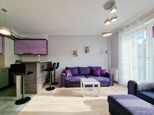 雷达CLASSY APARTMENTS - AQUAPARK Reda的客厅配有紫色沙发和电视