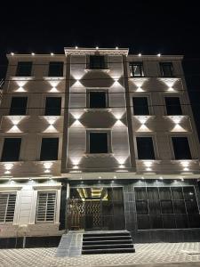 Ahad RafidahCast Home的一座白色的大建筑,晚上有灯