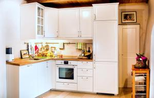 卡莱扎诺Bioagriturismo Podere Montisi的白色的厨房配有白色橱柜和冰箱。