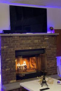 托比汉纳Oceans - KING BED Cabin Loft & Fireplace的砖砌壁炉,壁炉里放着火