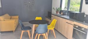 Flassans-sur-IssolePetit paradis sur golf的厨房配有黄色和蓝色的椅子和桌子