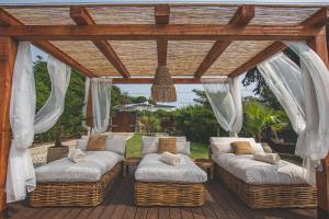 埃斯托利尔Villa Pietra Estoril Eco Guesthouse的甲板上带柳条沙发的凉亭