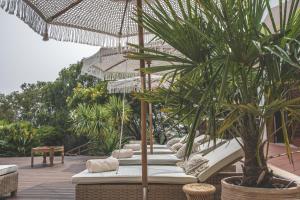 埃斯托利尔Villa Pietra Estoril Eco Guesthouse的一个带椅子和遮阳伞的庭院