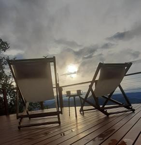 新彼得罗波利斯Recanto Ninho das Aguias的两把椅子坐在甲板上,背面是太阳