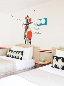 Mancos梅萨维德汽车旅馆的墙上有标牌的房间的两张床