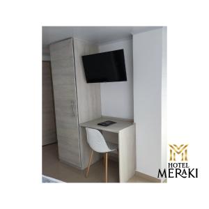 波帕扬Hotel Meraki Popayán的小房间设有书桌和电视