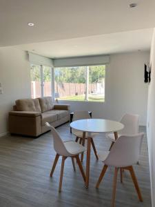 贝拉维斯塔Casa para 4 personas en vista24uy, Bella Vista, Maldonado的客厅配有桌椅和沙发