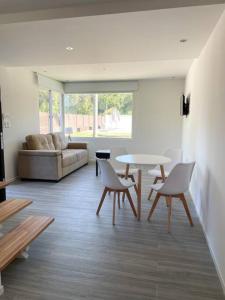 贝拉维斯塔Casa para 4 personas en vista24uy, Bella Vista, Maldonado的客厅配有桌椅和沙发