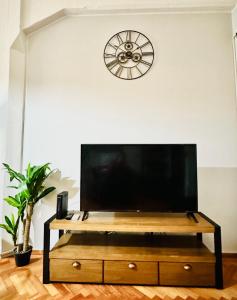布宜诺斯艾利斯Madero Apartment的客厅设有一台带时钟的电视台和一台平面电视