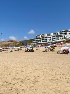 塞拉Jawharat plage des nations的一群人,在海滩上,有建筑背景