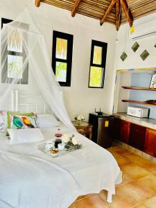 FilipinaVilla La Fortuna Altos del Maria的卧室配有一张白色的床,上面放着一盘食物