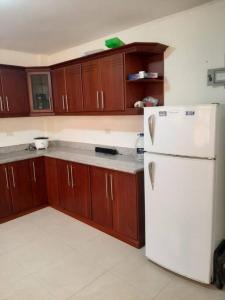 洛哈Andaluz Townhouse for Rent的厨房配有白色冰箱和木制橱柜。