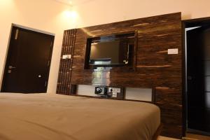 埃尔加德Melody Inn的一间卧室配有一张床,墙上配有电视