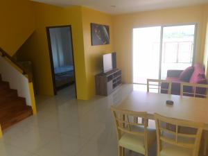 Ban Khlong KrangYYK Homestay的客厅设有餐桌和电视