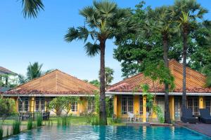 亭可马里Palmera Eco Resorts Nilaveli的棕榈树和游泳池的房子