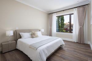 里士满Vancouver Vacation Home的白色的卧室设有床和大窗户