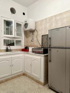 GabèsDar almasyaf, maison bord de mer的厨房配有白色橱柜和冰箱。
