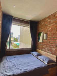 岘港IKIGAI Dorm Hostel - Danang Beach的砖墙房间的一个床位
