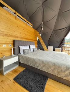 卡兹贝吉Elia Glamping的一间卧室设有一张床和木墙