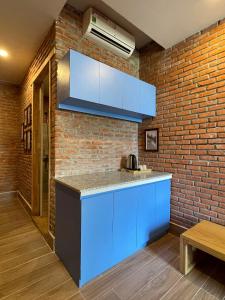 岘港IKIGAI Dorm Hostel - Danang Beach的厨房配有蓝色橱柜和砖墙