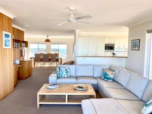 扬巴Pippi Beach Penthouse的客厅配有蓝色的沙发和桌子