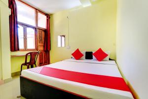 SabariOYO Flagship 71257 Hotel Matri Smriti的一间卧室配有一张带红色枕头的大床
