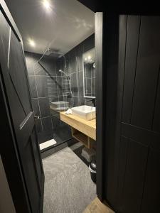 圣莫里斯堡Arcs 1950 Appartement prestige Ski InOut 6 pax的黑色浴室设有水槽和浴缸。