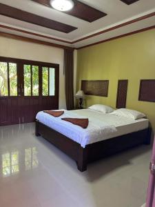 通奈潘海滩布达拉克撒旅馆的一间卧室,卧室内配有一张大床