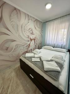 弗尔尼亚奇卡矿泉镇Spa apartman Sobhe的一间有女人壁画的卧室