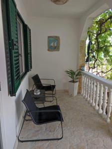 克拉帕尼岛Kuća za odmor TAJANA的窗户客房内的两把椅子和一张桌子